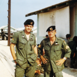 CCN, Apr 69-Myself & Mark, standing next to US Mess Hall, camera is facing east toward Recon Com. Area. By John S. “Tilt” Meyer